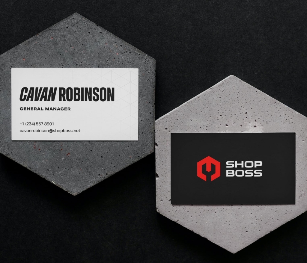 Two Shop Boss business cards set atop concrete hexagons.