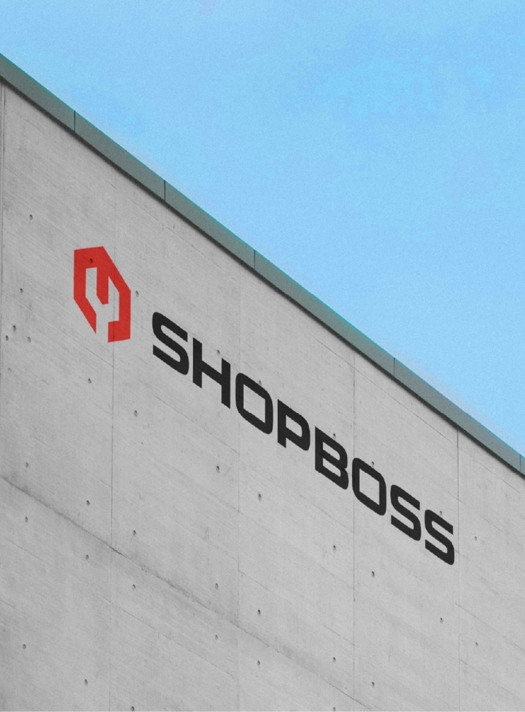 A concrete building displaying the Shop Boss logo.